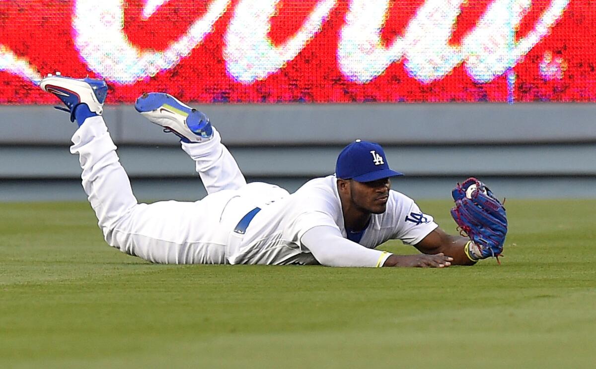 Dodgers outfielder Yasiel Puig slides after making a diving catch on a ball hit by Mets outfielder Juan Lagares during the first inning of a game at Dodger Stadium on May 10.