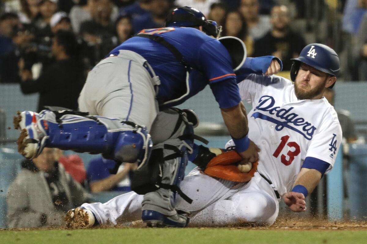 Dodgers second baseman Max Muncy slides safely under the tag of New York Mets catcher Wilson Ramos to score in the third inning on Wednesday night at Dodger Stadium.