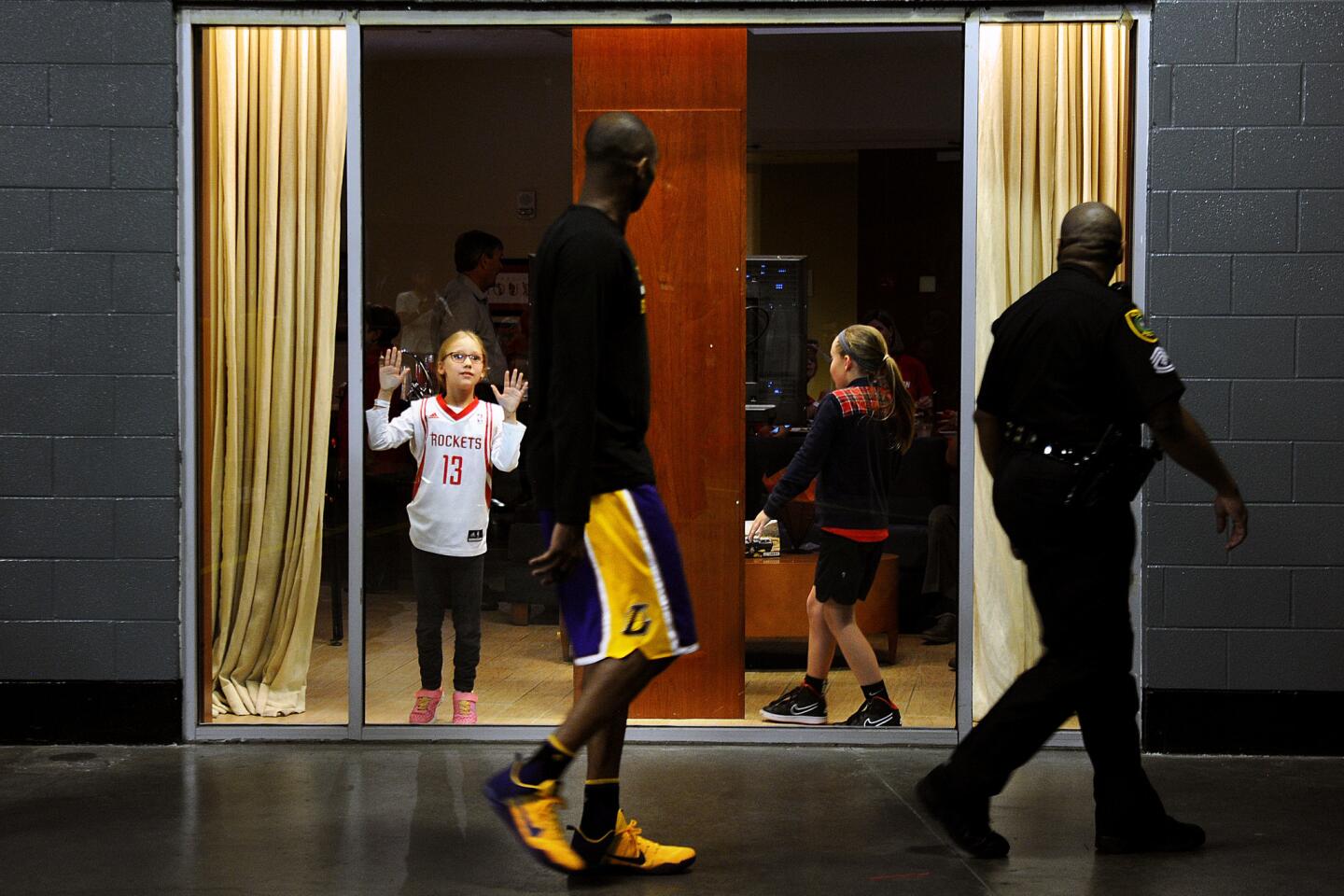 Laker Kobe Bryant walks by a young Rockets fan as he makes his way to the court during halftime in Houston.
