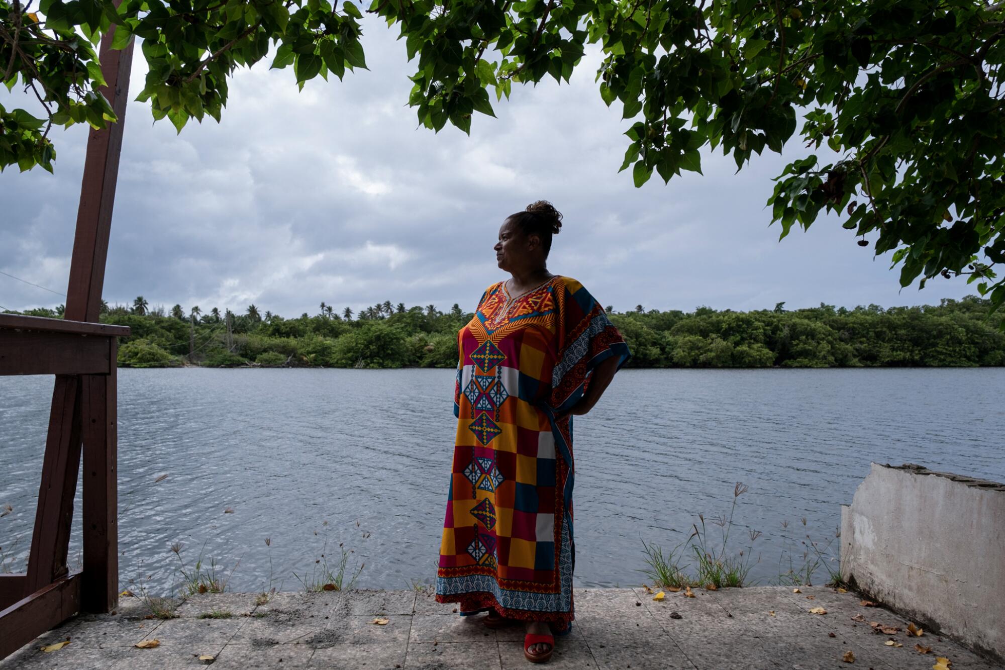 Modesta Irizarry standing under a tree next to a river