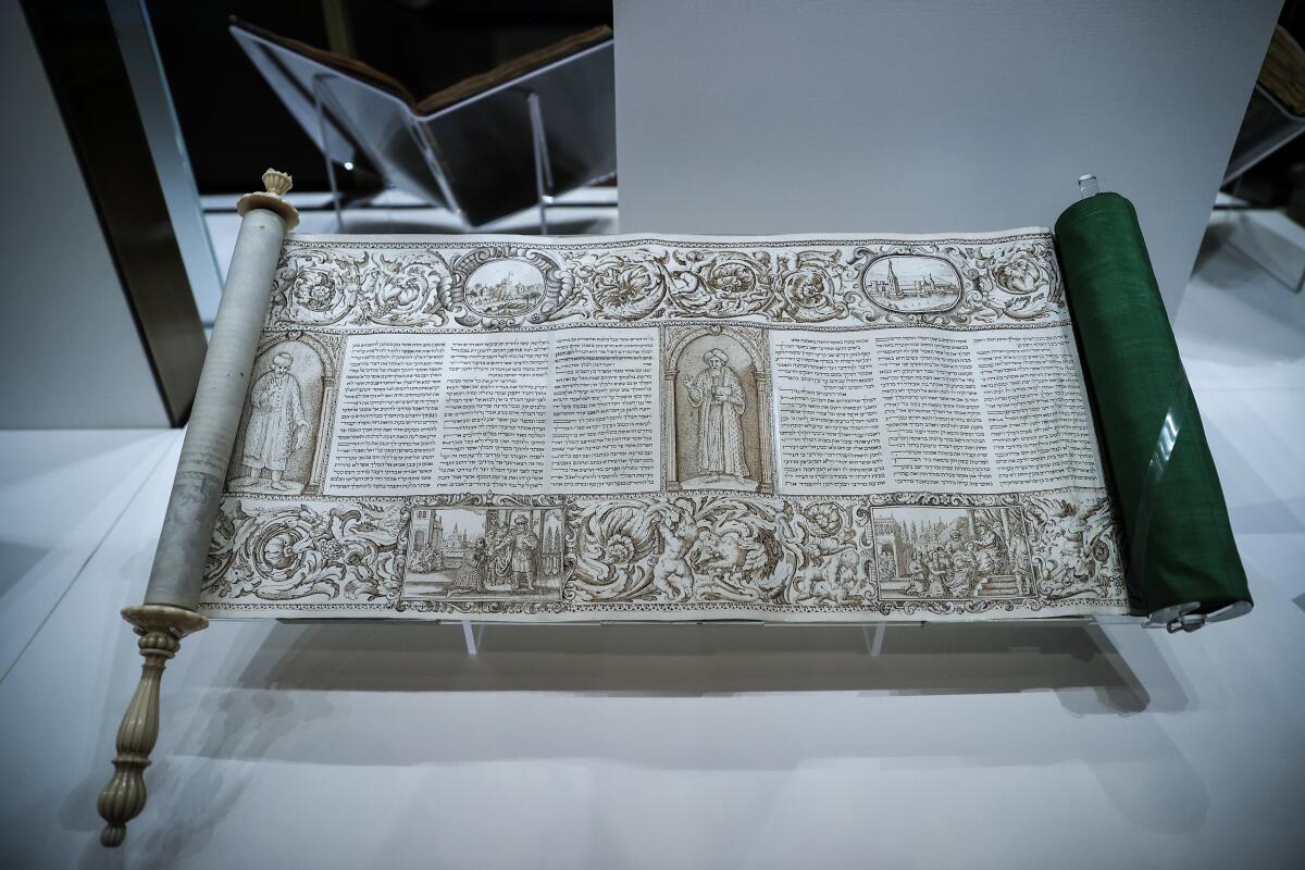 An elaborately lettered and illustrated biblical scroll partly unfurled. 