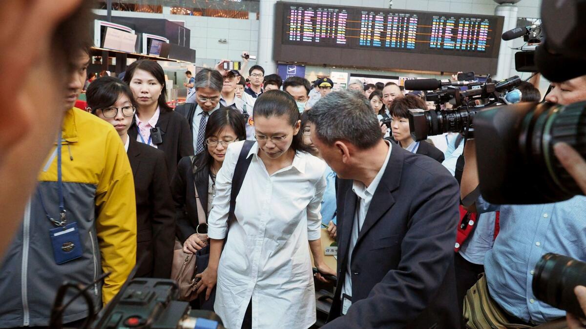 Li Ching-yu, center, wife of Taiwanese human rights activist Li Ming-che, who is being detained in China, leaves the Air China check-in counter at the Taoyuan International Airport in northern Taiwan on April 10, 2017. (David Chang / European Pressphoto Agency)