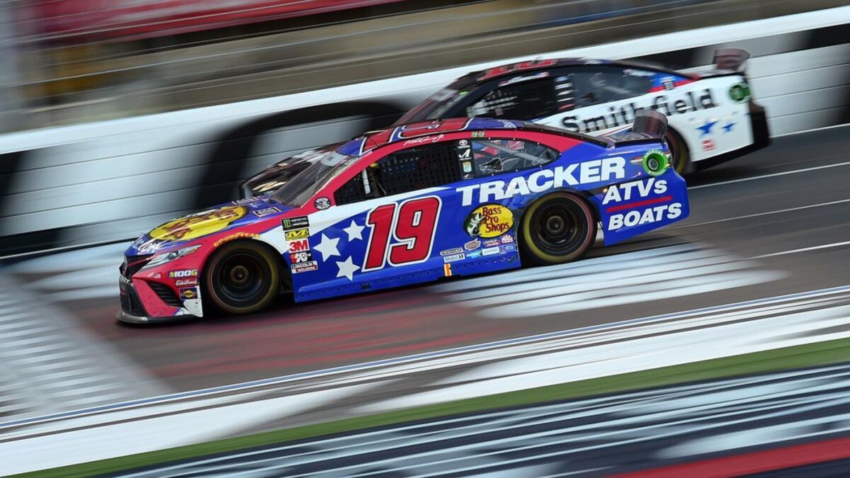 NASCAR driver Martin Truex Jr., (19) races side-by-side with Aric Almirola during the Coca-Cola 600 on Sunday.