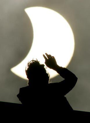 A woman looks at a partial solar eclipse in St. Petersburg, Russia.