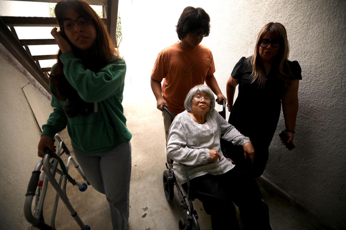 Rosa Angelica Saldana, 81, in wheelchair, is helped home by her grandchildren and their mother. 

