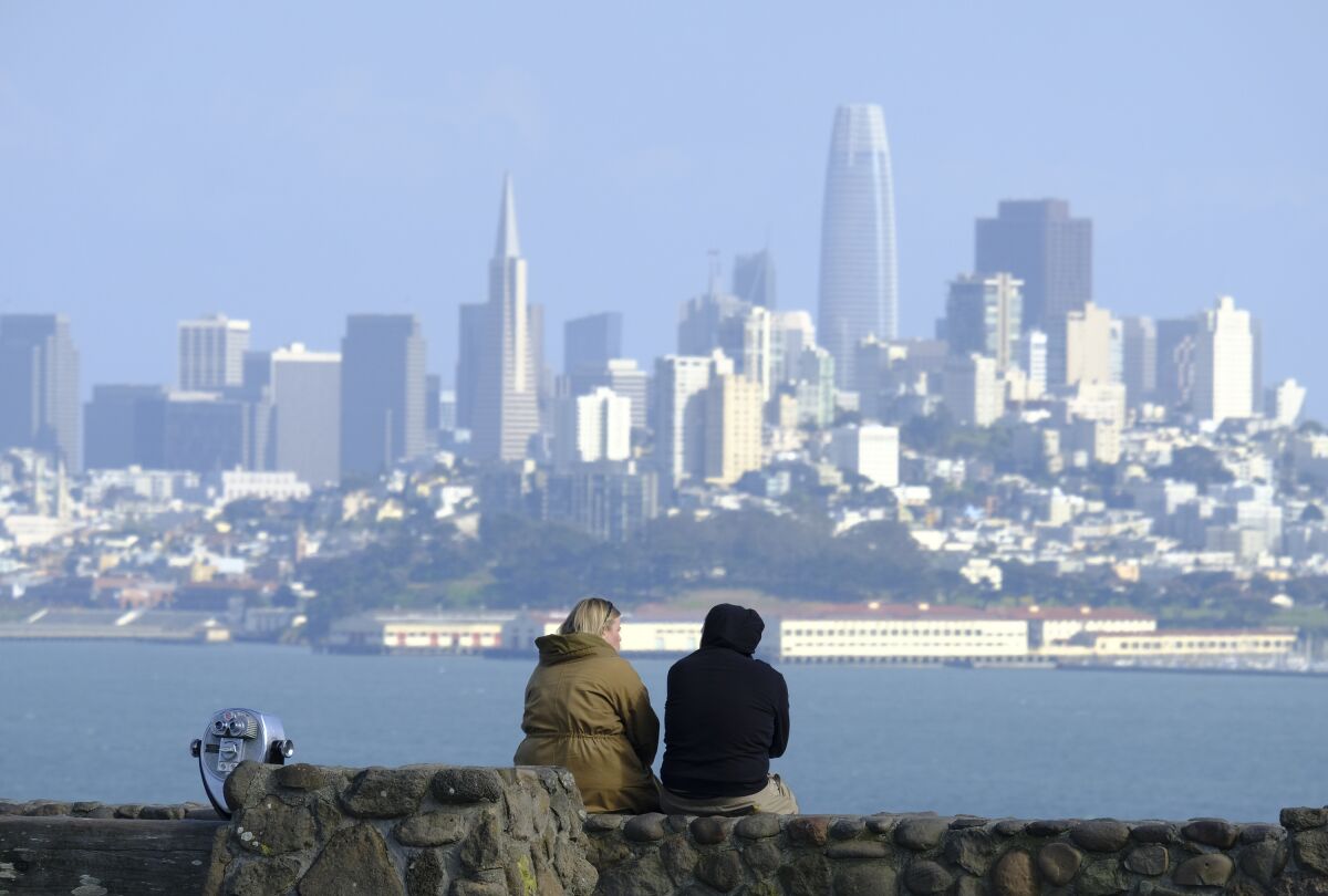 A couple view the San Francisco skyline from a vista point in Sausalito, Calif., in March.