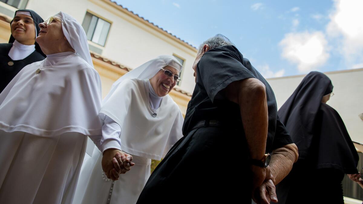 Sister Maria Socorro, center, mingles with priests and fellow nuns after a first vows ceremony.