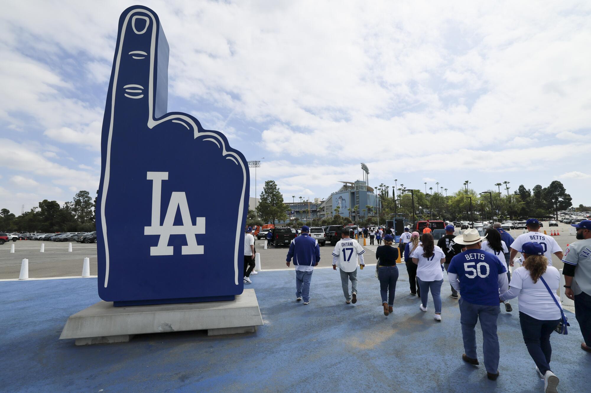 Fans walk to the gates in the parking lot of Dodger Stadium before a against the Detroit Tigers on March 27.