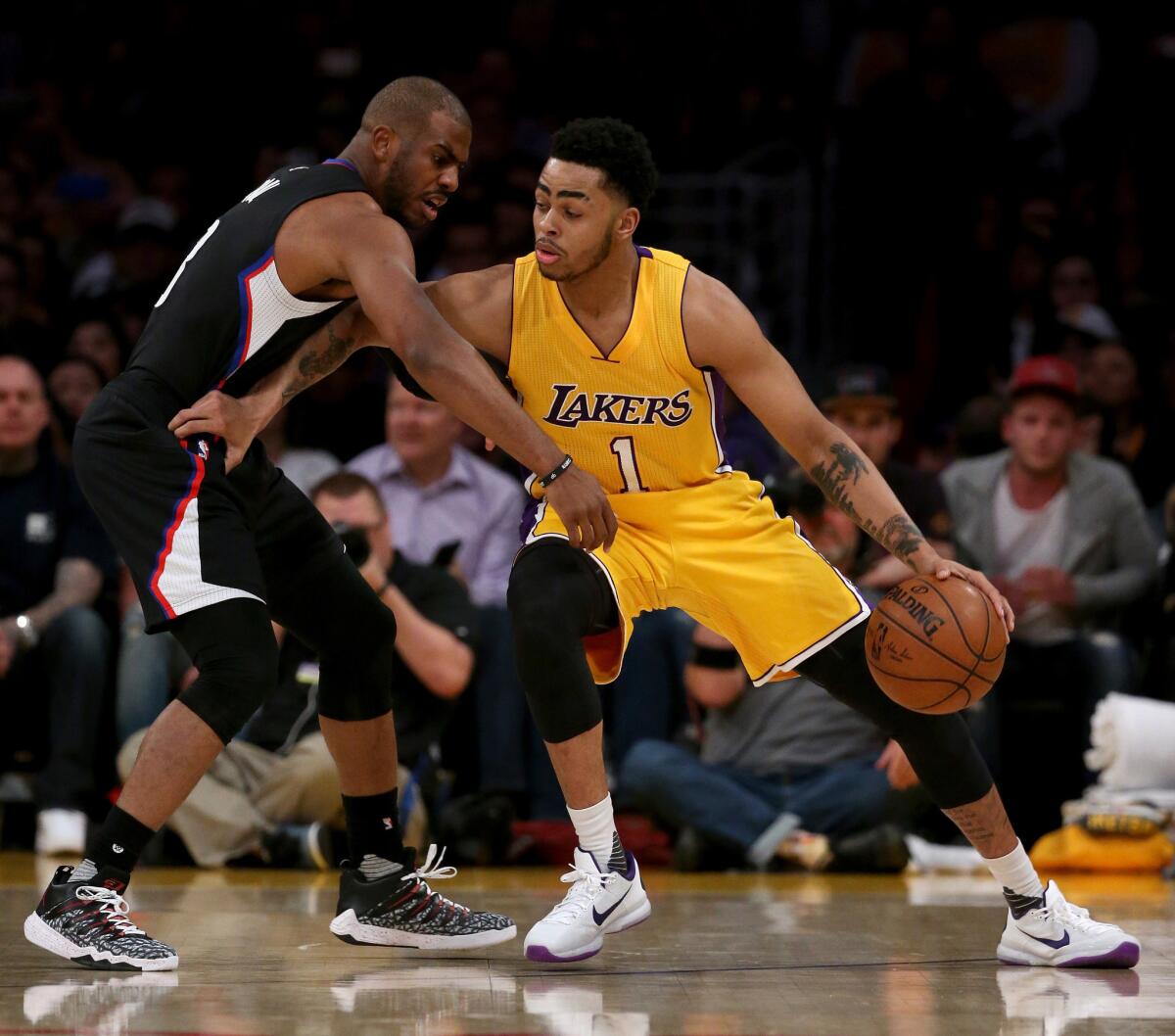 Clippers guard Chris Paul, shown defending against Lakers guard D'Angelo Russell last season, did not play in the Christmas night loss to their rivals this season.