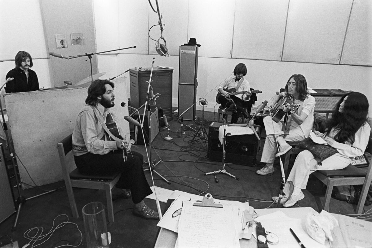 A band seated in a recording studio.