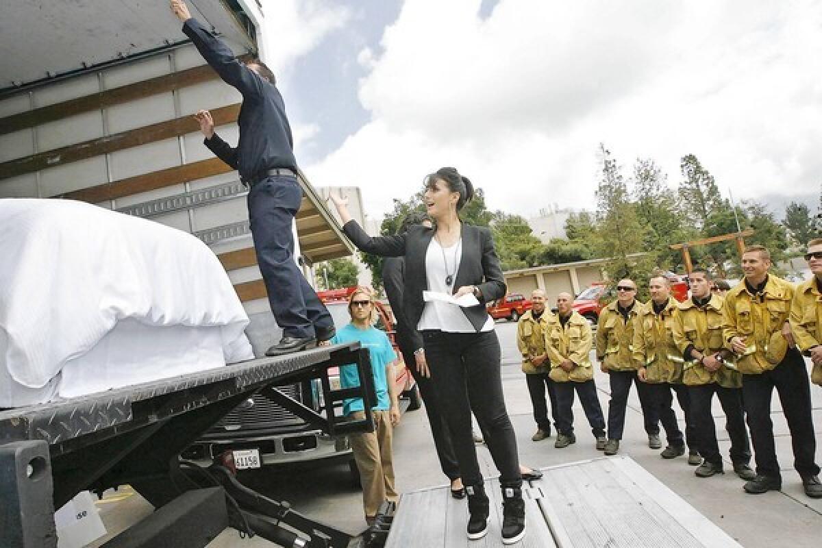 Actress Emmanuelle Chriqui and LA County Capt. Pat Sprengel unveil a truck full of new mattresses donated by the Westin Hotels to the firefighters of LA County Fire Camp 2 on Monday, April 15, 2013.