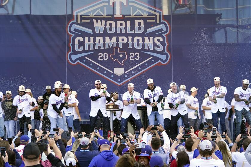 ARCHIVO - Los Rangers de Texas arrojan champaña a los fanáticos durante la celebración del título de la Serie Mundial, el viernes 3 de noviembre de 2023 (AP Foto/Julio Cortez, archivo)