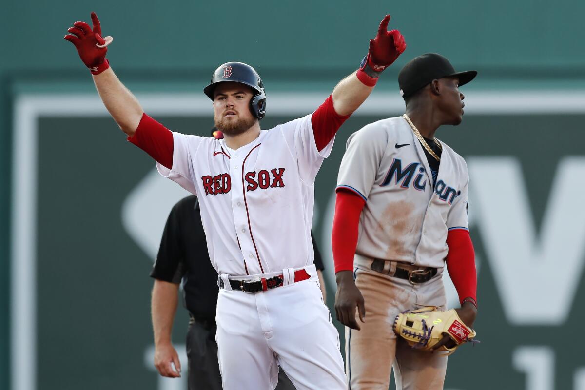 Boston Red Sox's Christian Arroyo, left, reacts beside Miami Marlins' Jazz Chisholm Jr. after hitting a two-run single during the fourth inning of a baseball game, Monday, June 7, 2021, in Boston. (AP Photo/Michael Dwyer)