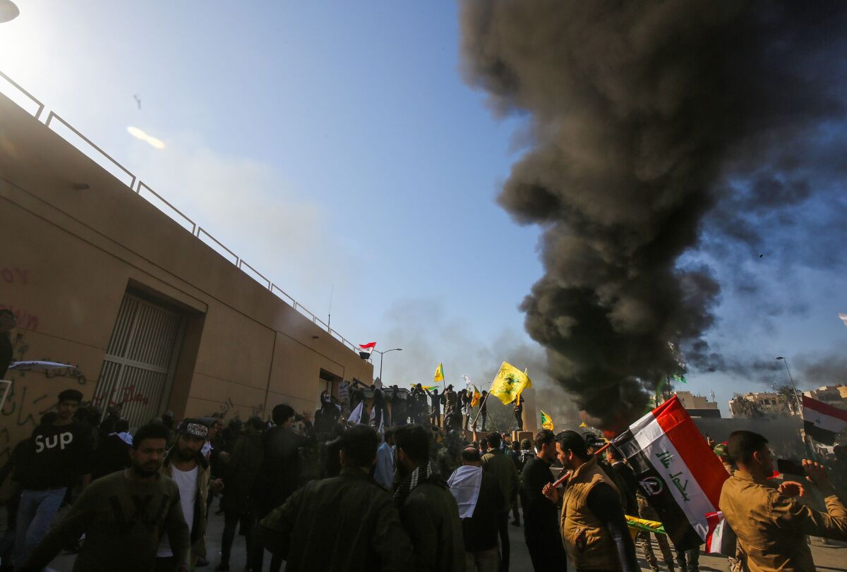 Iraqi protesters burn tires in front of the U.S. Embassy in Baghdad.  