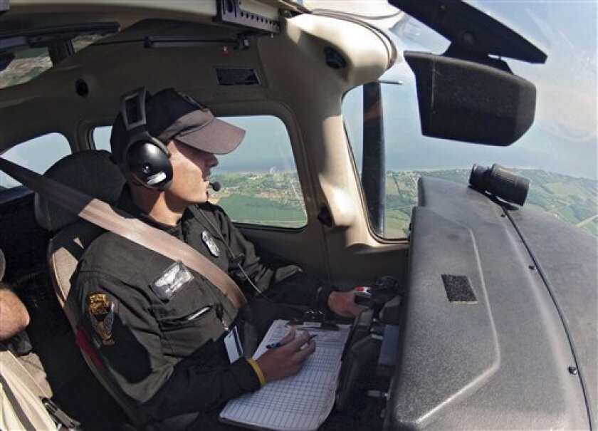 In this June 27, 2012 photo, Ohio State Highway Patrol trooper Bryan Dail hunts for speeders from an aircraft over Ohio Route 2 near Vermilion, Ohio. While Ohio still aggressively uses aircraft to catch speeders, many states have cut back or eliminated aerial enforcement due to budget concerns. (AP Photo/Mark Duncan)