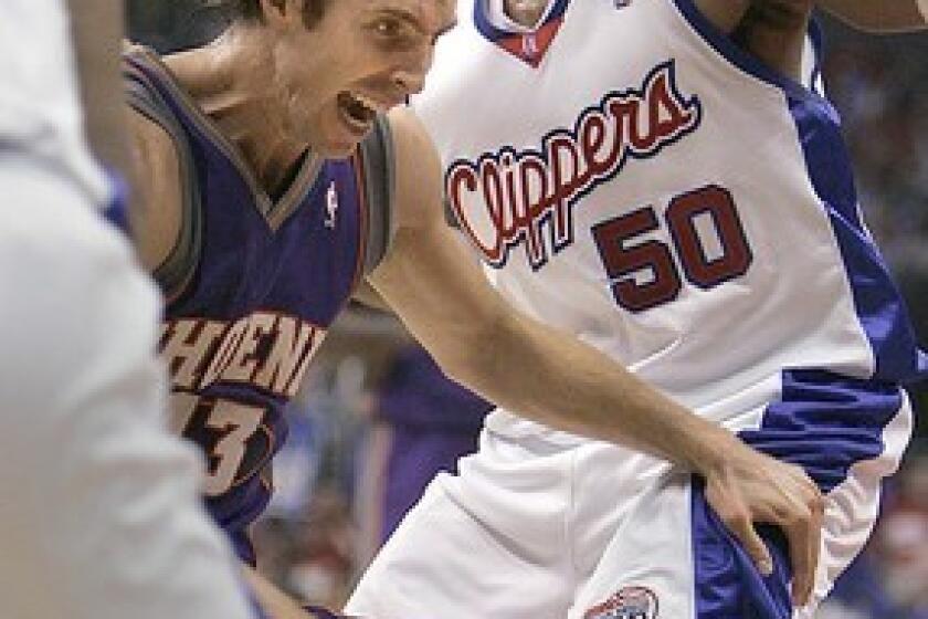 Los Angeles Clipper Corey Maggette tightly defends a driving Steve Nash.