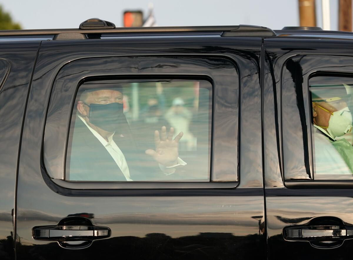 President Trump waves from an SUV