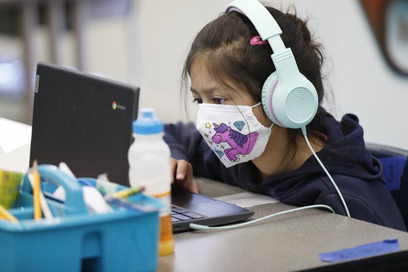 WEST HOLLYWOOD, CA - MARCH 18: Second grade student Sophia Rivera, 8, completing online study while sitting in front of the BARD HVAC unit with latest in HVAC technology in the "Beyond The Bell" classroom for students of employees on campus at West Hollywood Elementary School as Los Angeles Unified School District (LAUSD) Board Member Nick Melvoin, representing District 4 visits West Hollywood Elementary School and various other schools in his district to do an official check on preparations for reopening. The walking tour included the principal, Dr. Elizabeth Lehmann, LAUSD officials, a parent, West Hollywood Mayor Lindsay Horvath and Franny Parrish, with (CSEA), which represents school clerical workers and library aides, as they viewed modifications made to the school with COVID-19 considerations. West Hollywood Elementary School on Thursday, March 18, 2021 in West Hollywood, CA. (Al Seib / Los Angeles Times).