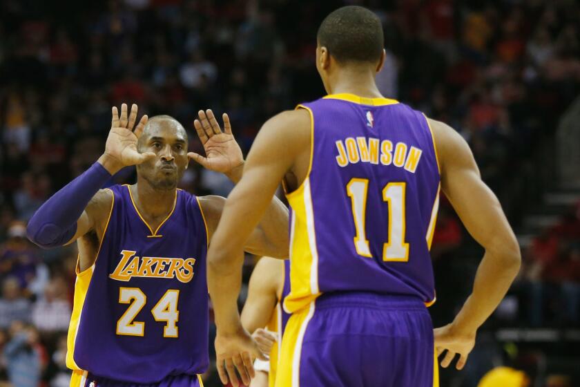 Lakers guard Kobe Bryant, left, celebrates with teammate Wesley Johnson in the closing seconds of a 98-92 win over the Houston Rockets on Wednesday.