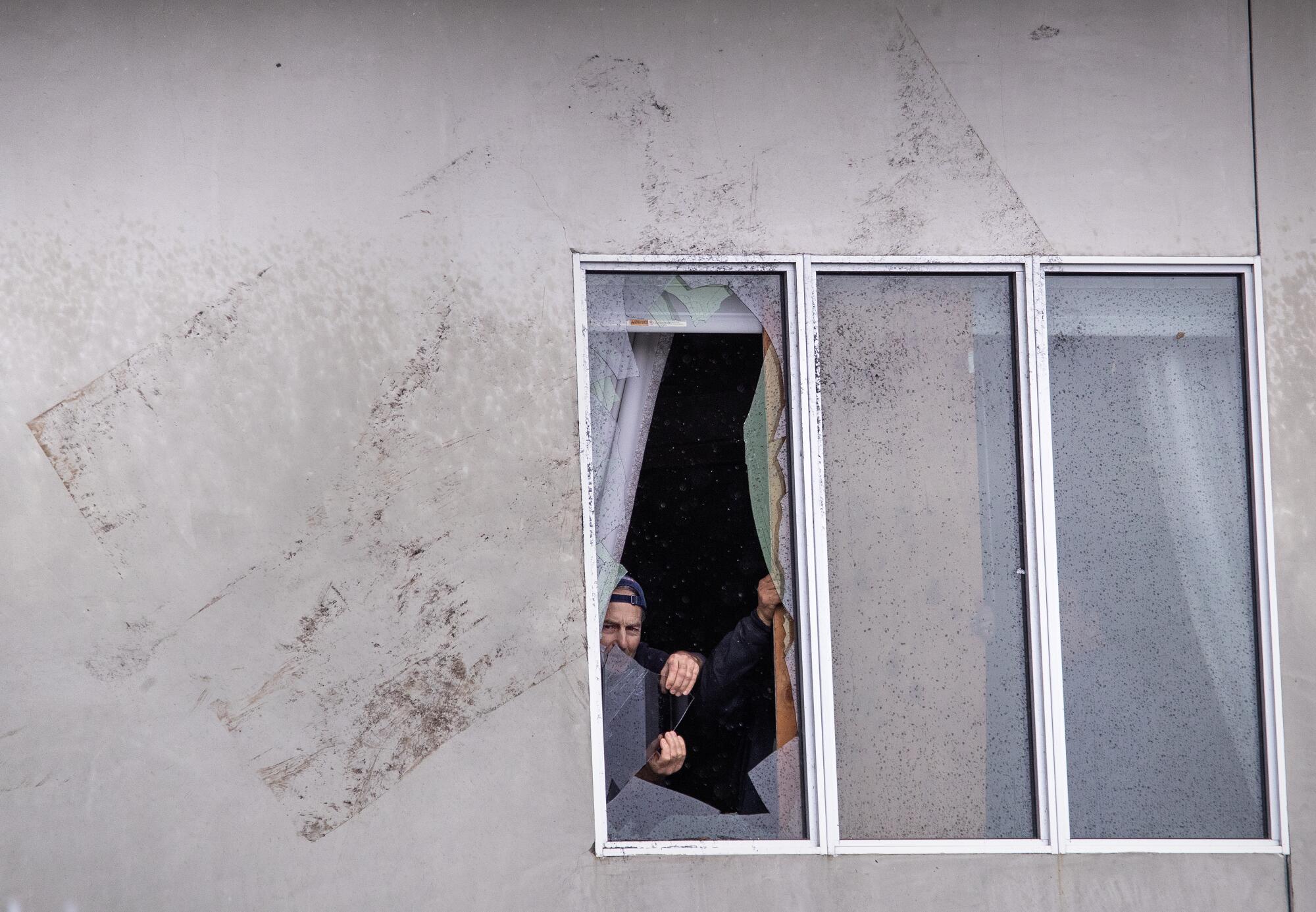 Workers remove broken glass from a window at a building in Montebello.
