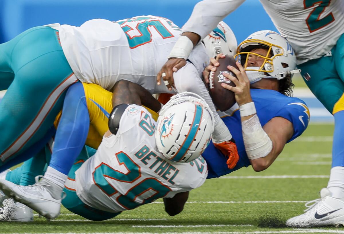 Chargers quarterback Justin Herbert is sacked by Miami Dolphins linebacker Jaelan Phillips (15) and cornerback Justin Bethel.