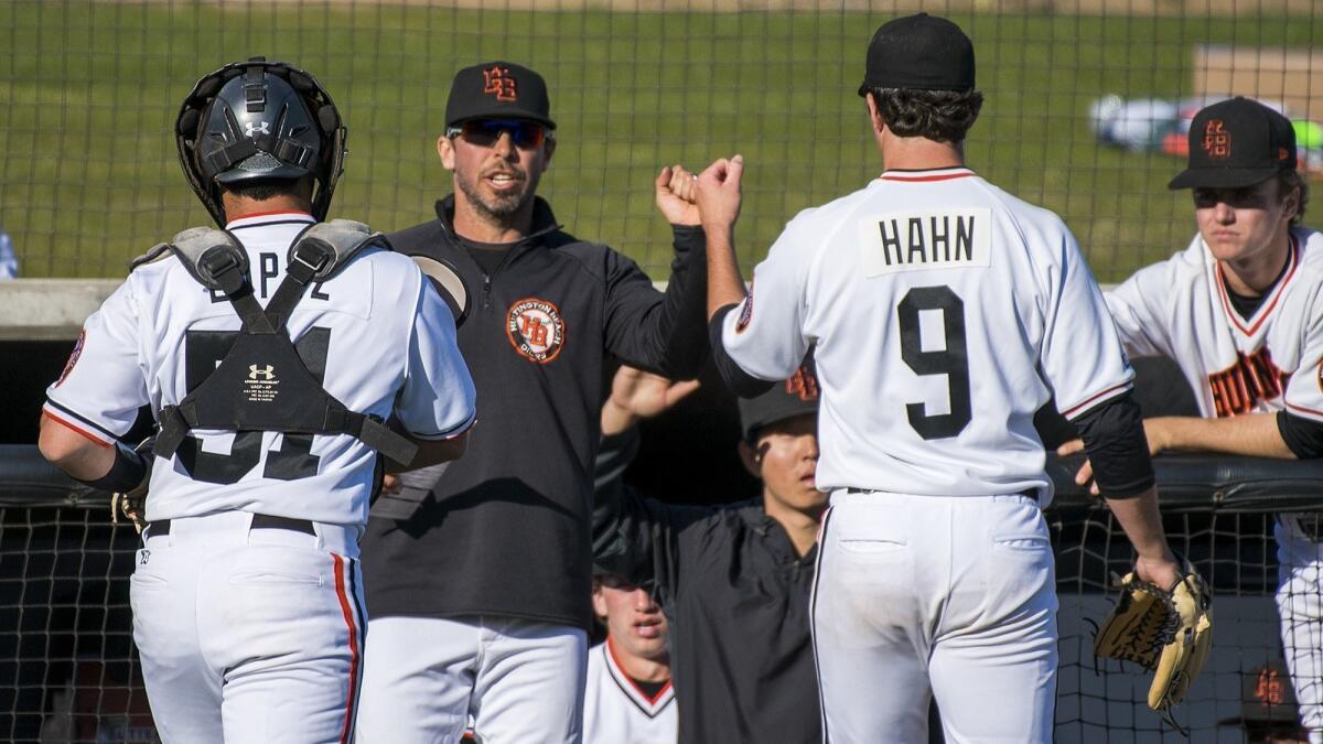 Josh Hahn (9) and Nick Lopez (51), shown walking to the dugout on March 1, 2018, both homered in Huntington Beach High's 10-7 win at Los Alamitos on Tuesday.