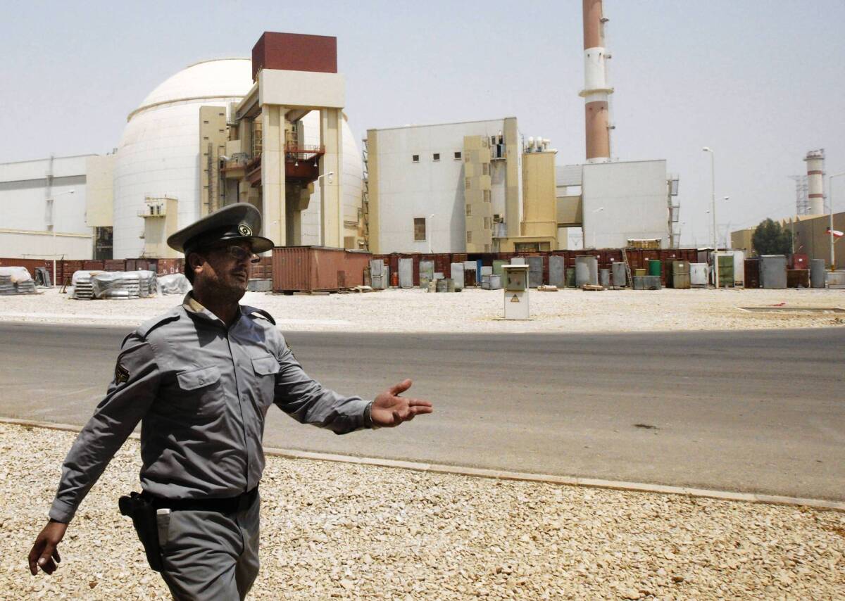 An Iranian security officers beckons to journalists at the Bushehr nuclear power plant in August 2010.