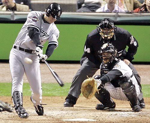 Chicago White Sox's Geoff Blum hits a solo home run in the 14th inning against Houston Astros reliever Ezequiel Astacio during Game 3 of the World Series in Houston. Looking on are home plate umpire Jerry Layne and catcher Brad Ausmus.