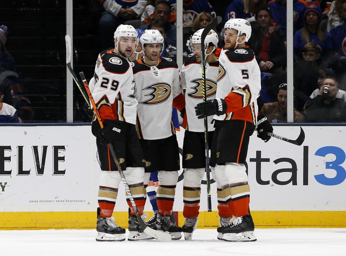 Ducks center Adam Henrique (14) celebrates a goal against the Islanders with teammates Devin Shore (29), Michael Del Zotto (44) and Korbinian Holzer (5) during the second period of a game Dec. 21.