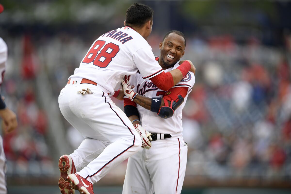 Washington Nationals' Alcides Escobar, right, celebrates his walkoff single that scored Tres Barrera (not shown) with Gerardo Parra (88) during the ninth inning of a baseball game against the San Diego Padres, Sunday, July 18, 2021, in Washington. (AP Photo/Nick Wass)