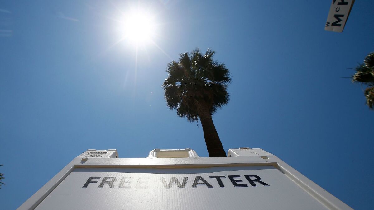 A Salvation Army hydration station sign sits in the midday sun as the temperature climbs to a near-record high in Phoenix. (Ross D. Franklin / Associated Press)
