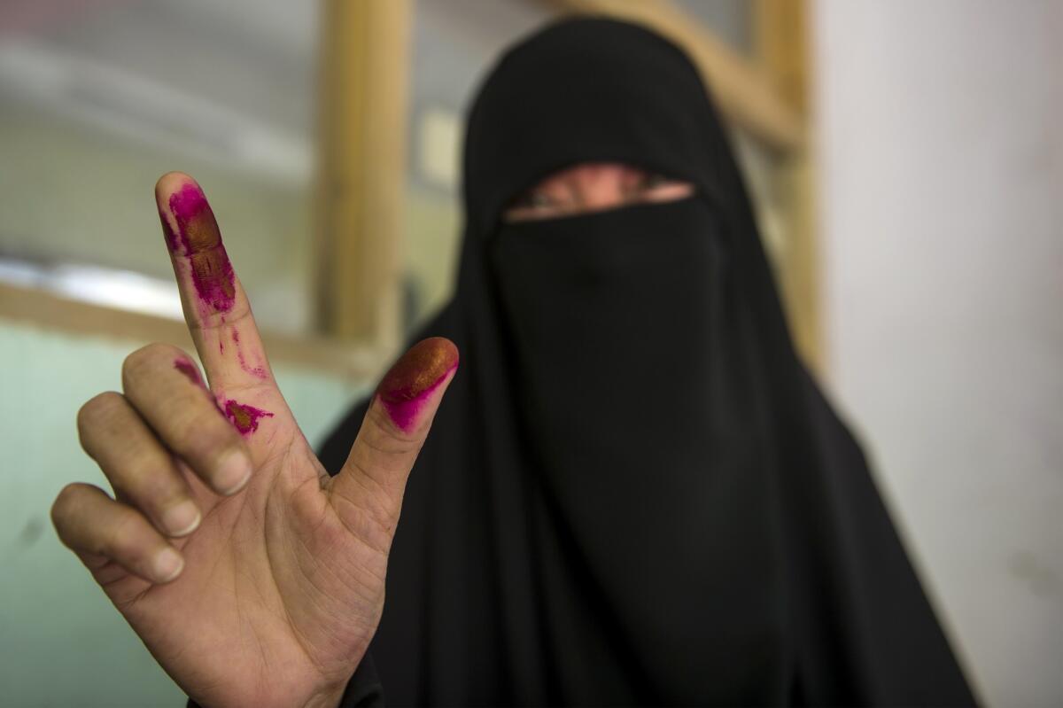 An Egyptian woman shows her ink-stained fingers after casting her vote at a polling station on the second day of Egypt's presidential election.