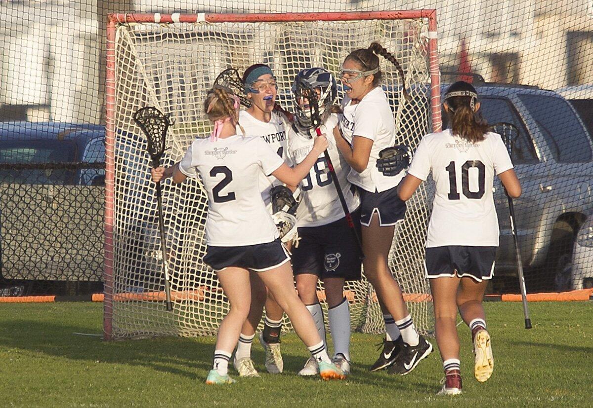 Newport Harbor High goalie Jade Rettig is swarmed by teammates after defeating Corona del Mar during the Battle of the Bay.