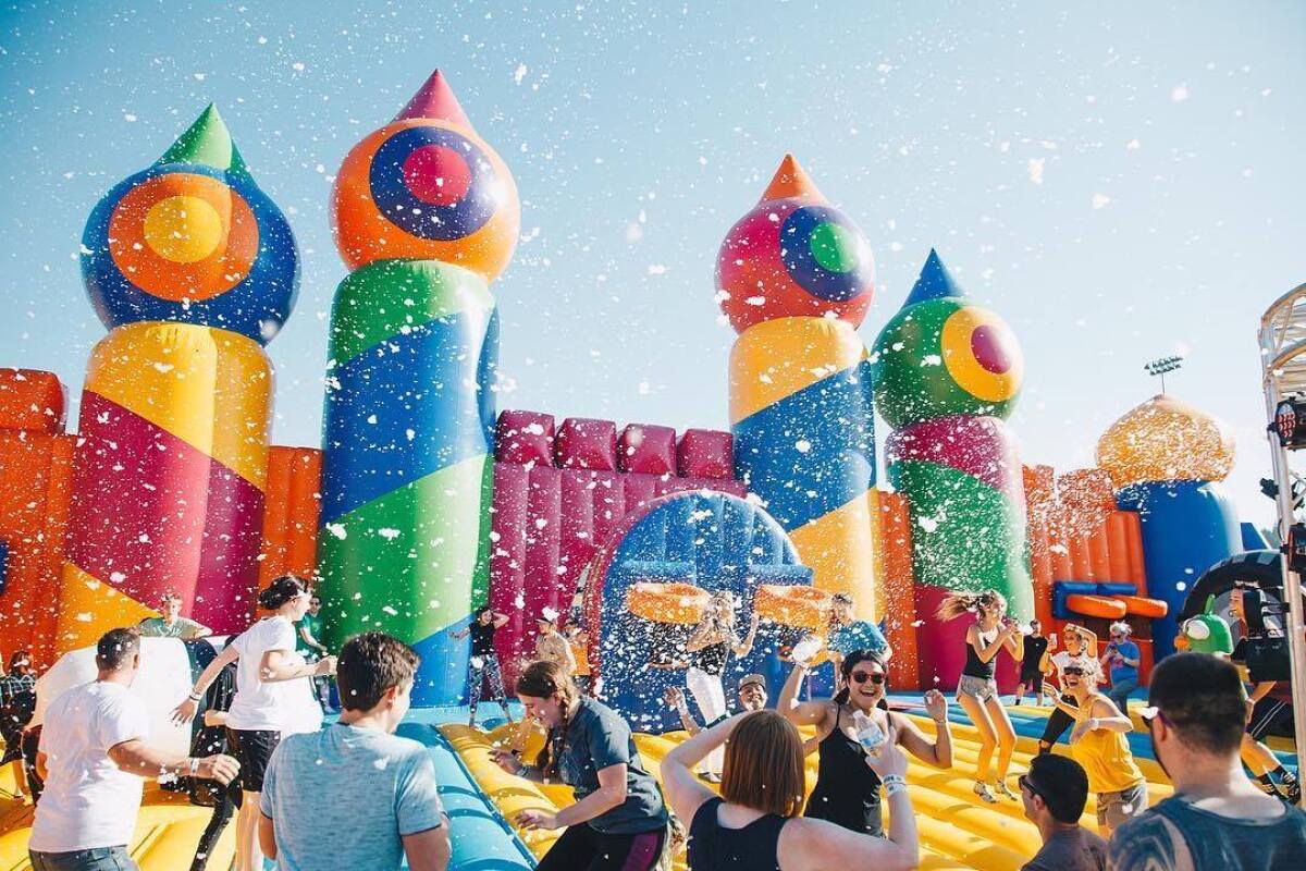 People jumping on large inflatables along an obstacle course.