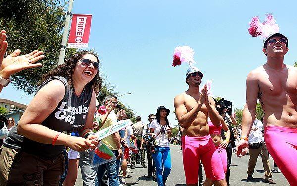 Parade goer Iliana Rivera, left, enjoys the L.A. Pride Parade in West Hollywood on Sunday.