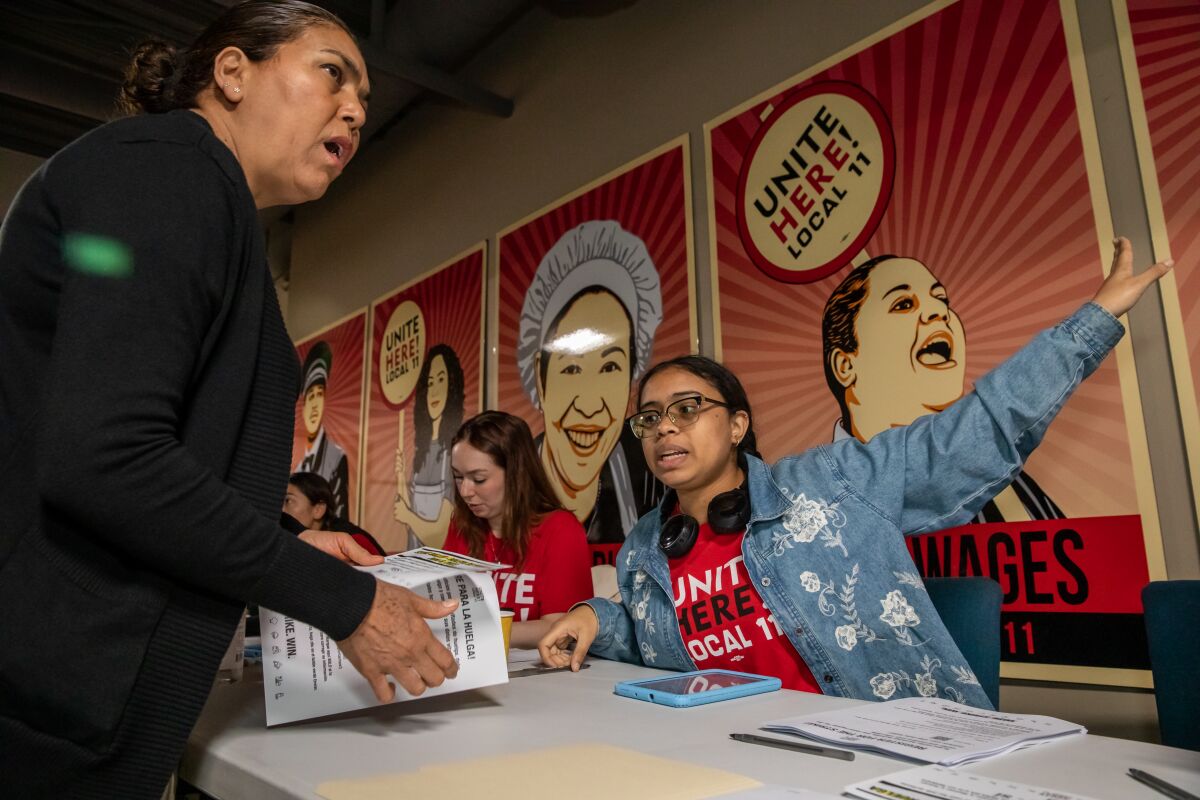 A young woman directs a hotel worker toward ballot boxes