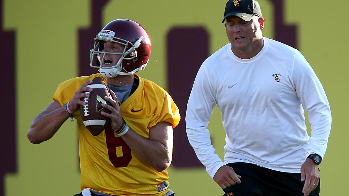 USC quarterback Cody Kessler, a high school star in Bakersfield like former Trojans All-American Frank Gifford, participates in a drill Saturday under the watch of offensive coordinator Clay Helton.
