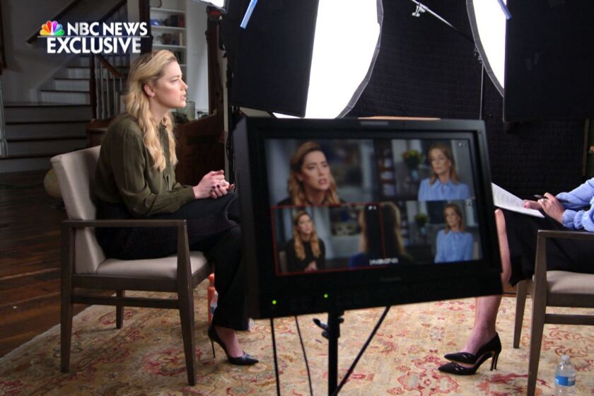 A female actor and a female journalist sit amid lights and a TV monitor for a broadcast interview