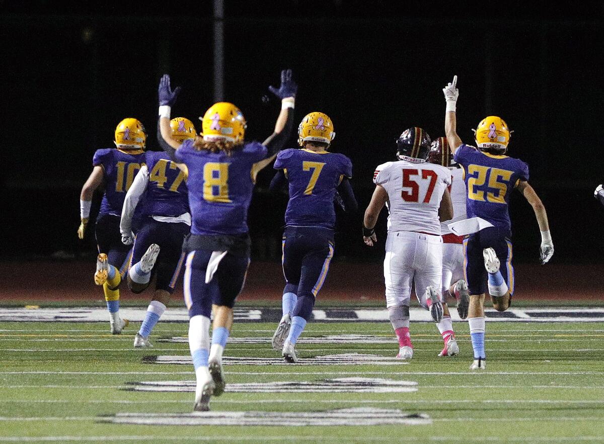 Marina players celebrate as Wyatt McClour (10) returns a fumble 67 yards for a touchdown in a Big 4 League game against Segerstrom at Westminster High on Friday.