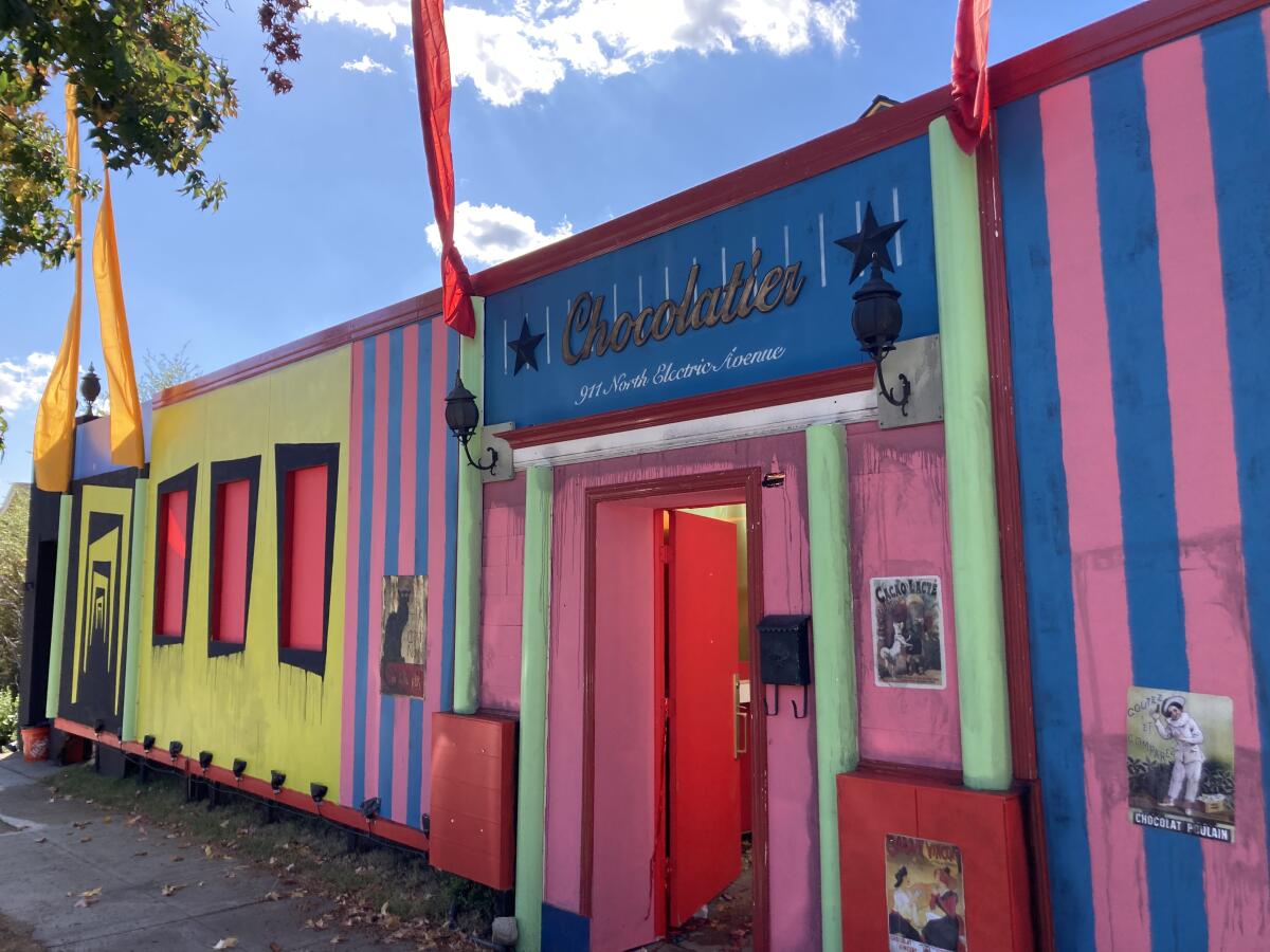 A multicolored store front with a sign above a door saying "chocolatier."