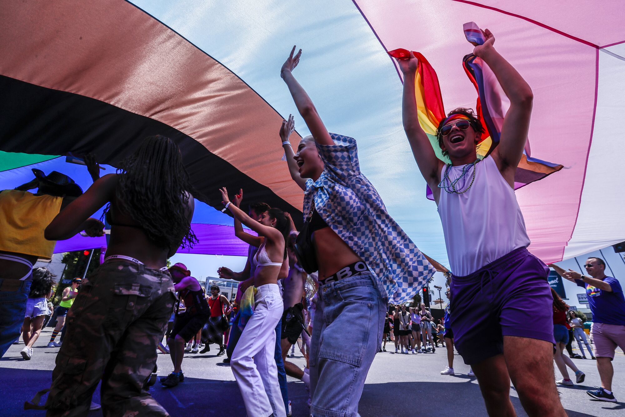People celebrating under a gigantic pride flag