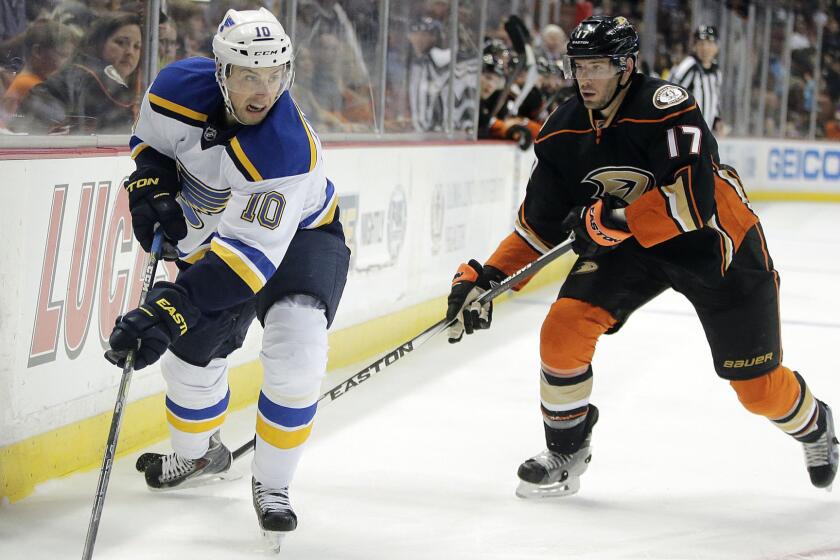 St. Louis Blues center Joakim Lindstrom, left, controls the puck in front of Ducks center Ryan Kesler during the Ducks' 3-0 victory Sunday.