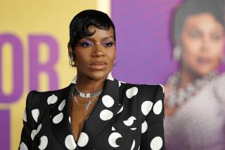 Fantasia Barrino with short black hair wearing a black-and-white polka dot dress and silver jewelry posing