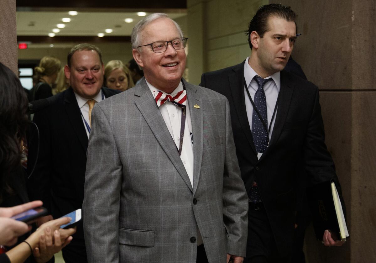 U.S. Rep. Ron Wright walks down a hall with people behind him in 2018.