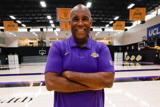 Longtime sports broadcaster Derrin Horton stands on the Lakers' practice court with arms folded for a photo.