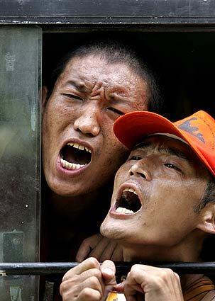 Exiled Tibetan monks shout slogans against the Chinese government as they are detained inside a police bus after a demonstration outside the U.N. office in New Delhi against the Beijing Olympics and Chinese occupation of Tibet.