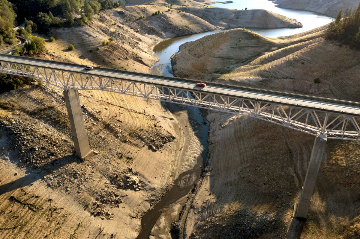 Vehicles cross the Enterprise Bridge at Lake Oroville, with water levels in the biggest state reservoirs well below average.