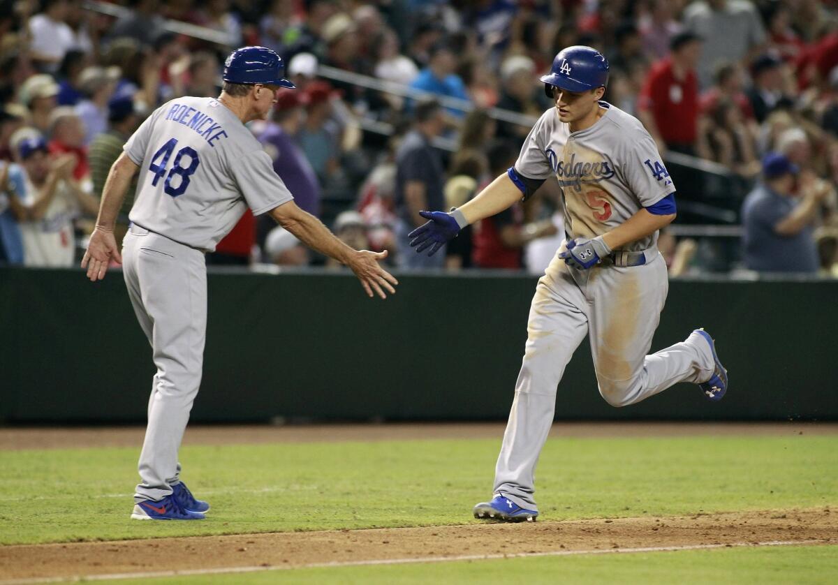 Corey Seager is congratulated by third base coach Ron Roenicke after homering Saturday.