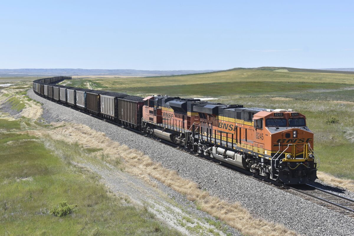 FILE - A BNSF railroad train hauling carloads of coal from the Powder River Basin of Montana and Wyoming is seen east of Hardin, Mont., on July 15, 2020. The major freight railroads are hiring aggressively and asking customers to cut the number of carloads they are shipping to reduce congestion along the rail network in response to concerns from agricultural and ethanol groups that prompted regulators to schedule a hearing on the problems. (AP Photo/Matthew Brown, File)