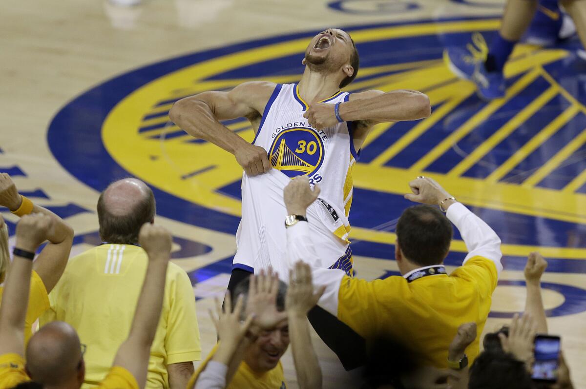 Fans cheer as Warriors guard Stephen Curry yells following Golden State's 96-88 victory over the Thunder in Game 7.